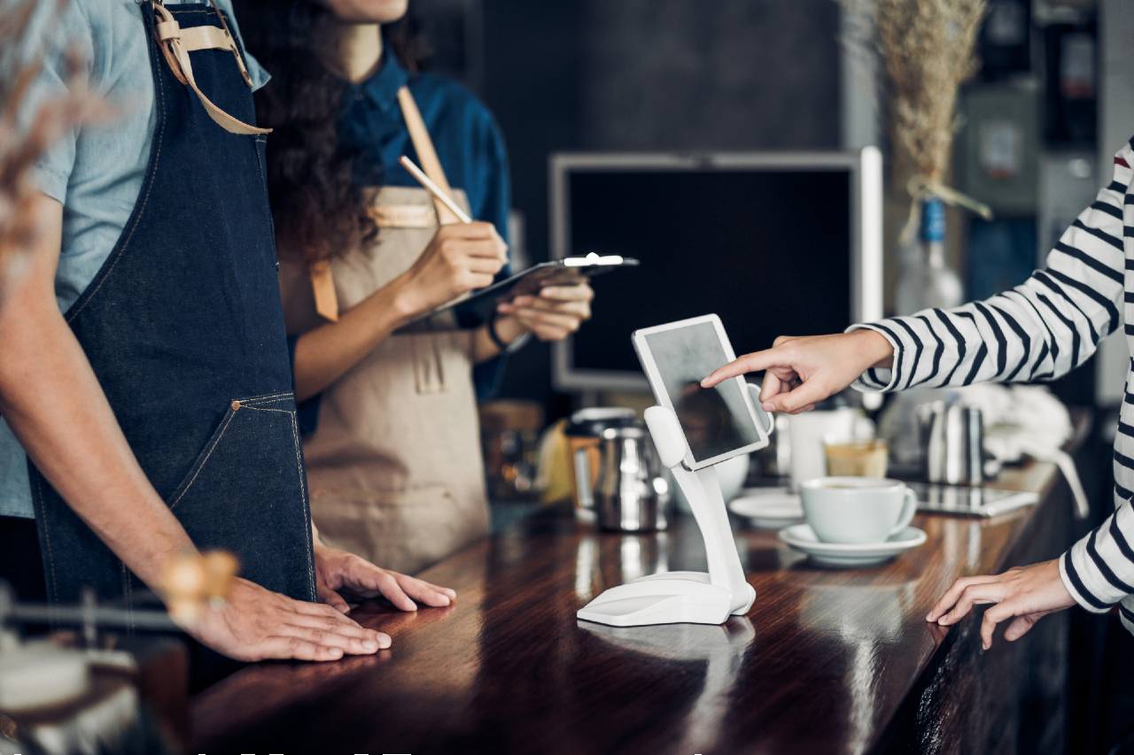 Lady using self service kiosk at cafe